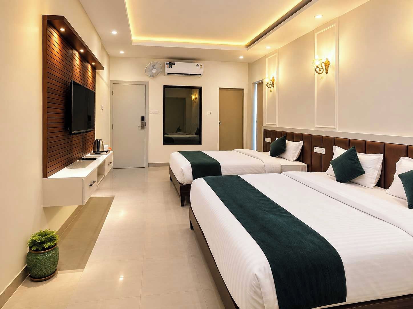A hotel room with two beds, a TV, an air conditioning unit, and a small potted plant.