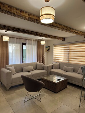 Ein modernes Wohnzimmer mit einer Eckcouch, einem Couchtisch und einem Sessel.