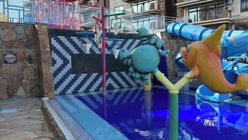 A swimming pool area with a water slide and a large crab decoration.