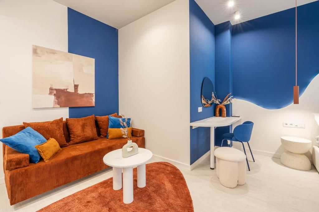 Ein modernes Wohnzimmer mit einer Couch, einem Couchtisch und einem Essbereich mit Stühlen und einem Tisch.