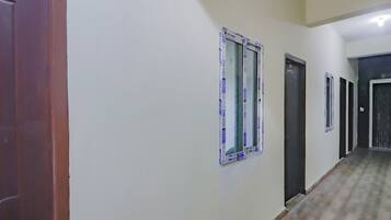 Un pasillo con puertas y ventanas, algunas cubiertas con plástico protector.