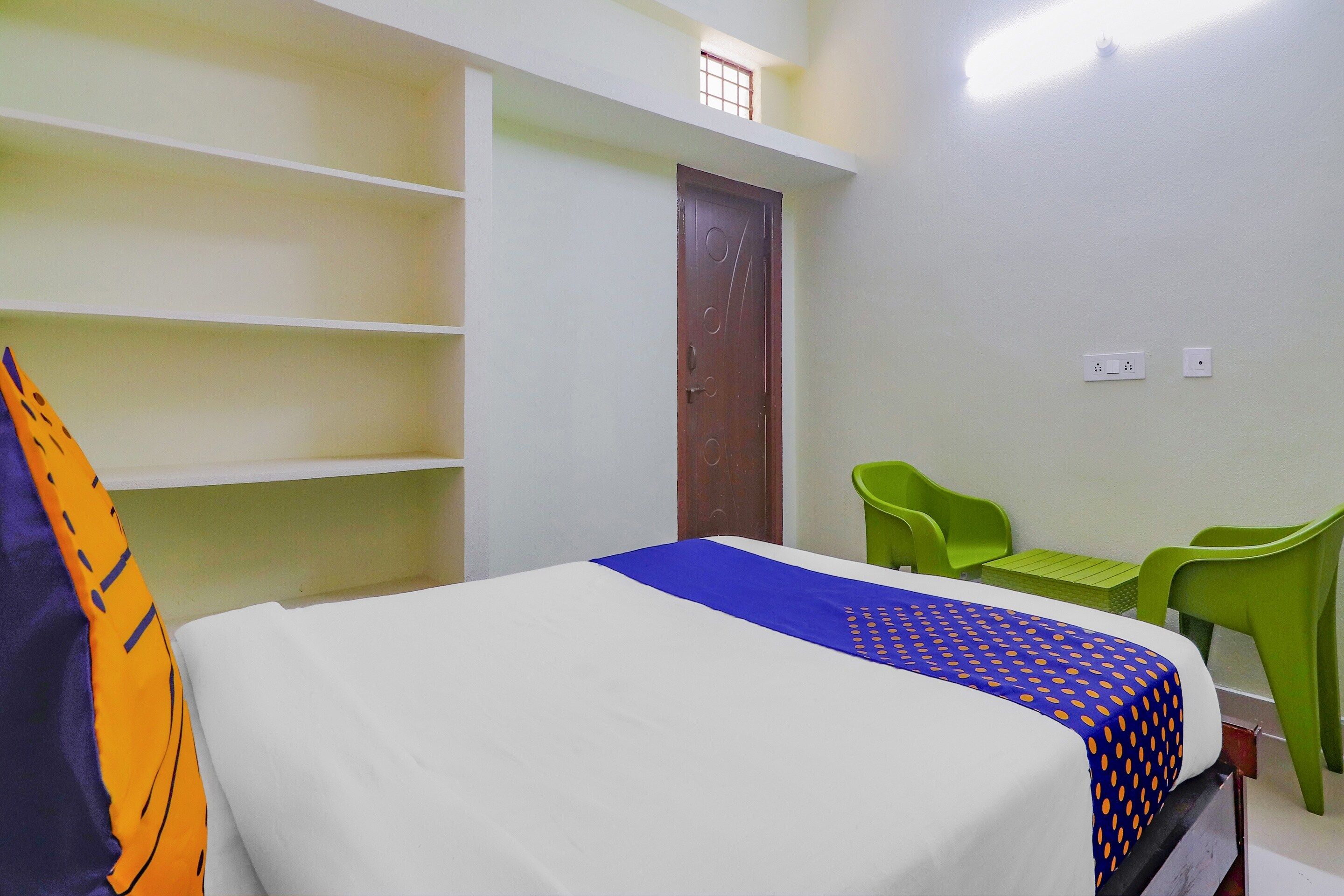 Una habitación con una cama, un escritorio y una silla. Tiene una puerta y una ventana.