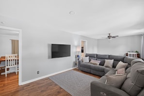 A modern living room with a grey sofa, a flat-screen TV, and a ceiling fan. - Walk to Jack Daniel Distillery & Lynchburg Square (Lynchburg)