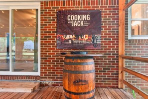 A brick wall with a sign for 'Cooking with Jack Daniel's' and a wooden barrel. - Walk to Jack Daniel Distillery & Lynchburg Square (Lynchburg)