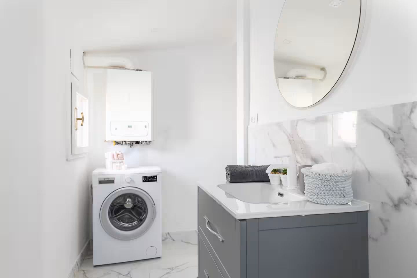 A modern bathroom with a built-in washing machine, a vanity with a mirror, and a marble backsplash.
