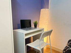 A small workspace with a laptop, a potted plant, and a chair. - Double Bed Partition Room in Al Barsha1 (Dubai)