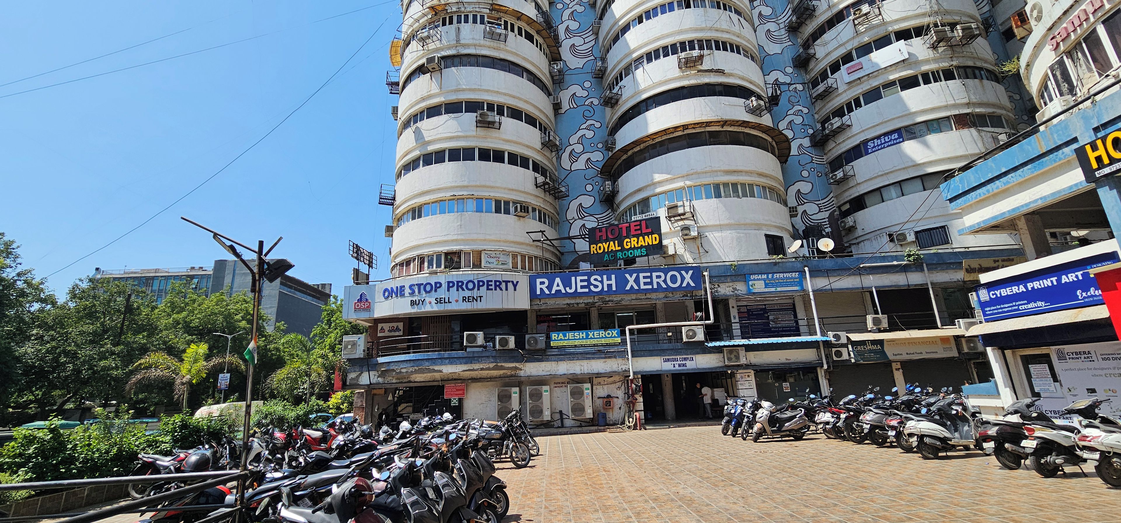 Un edificio de varios pisos con diversos establecimientos comerciales, incluyendo un hotel, servicios de administración de propiedades y una tienda de Xerox.