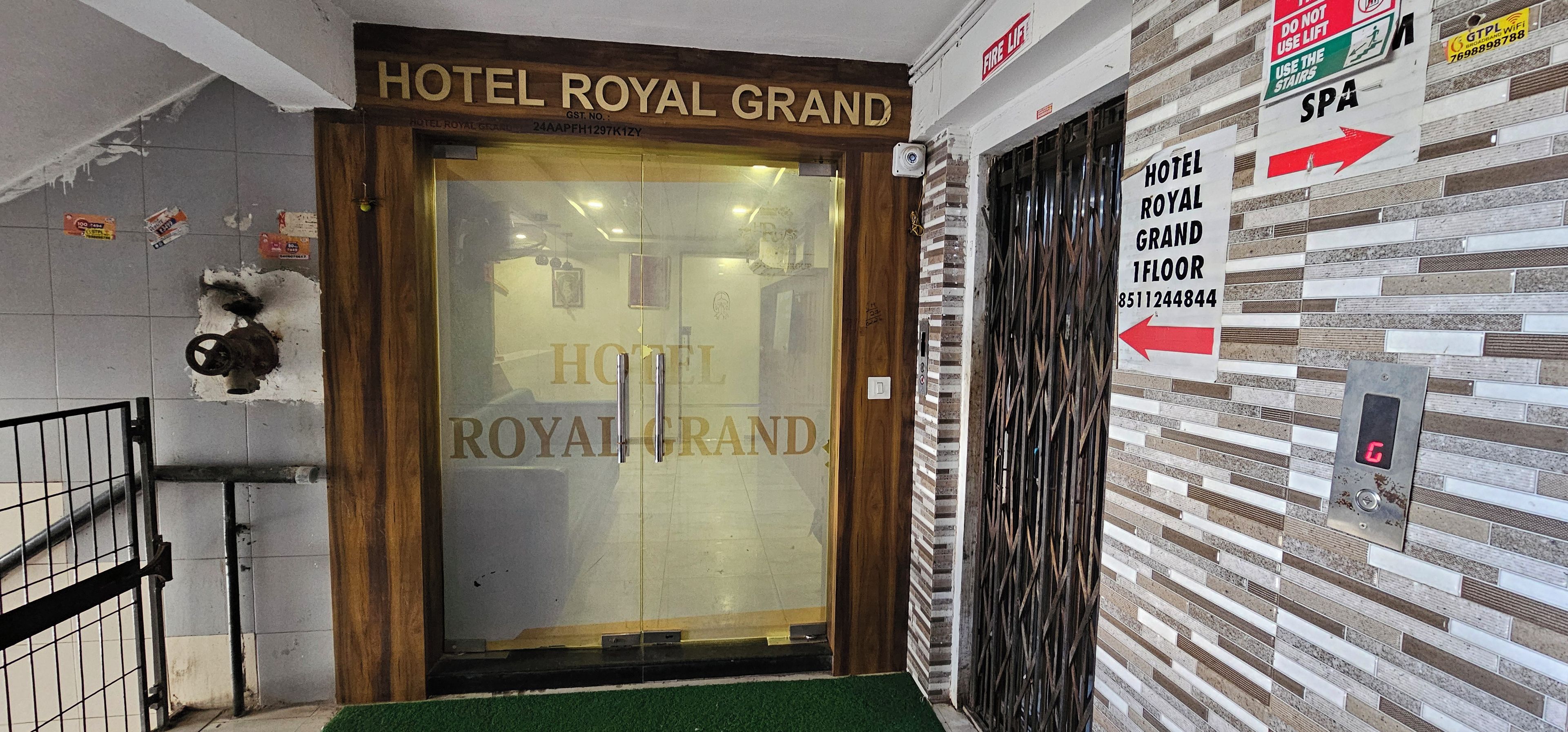 The entrance to Hotel Royal Grand with a clear sign, a fire lift sign, and a spa sign.
