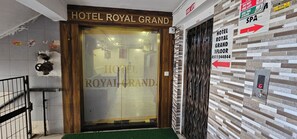 Ingången till Hotel Royal Grand med en tydlig skylt, en skylt som visar var brandtrappan finns och en skylt som visar var spaanläggningen ligger.