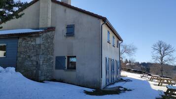 A two-story house with a stone facade and a blue window.