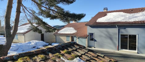 A residential area with houses, some with snow on the roofs, and a clear sky.