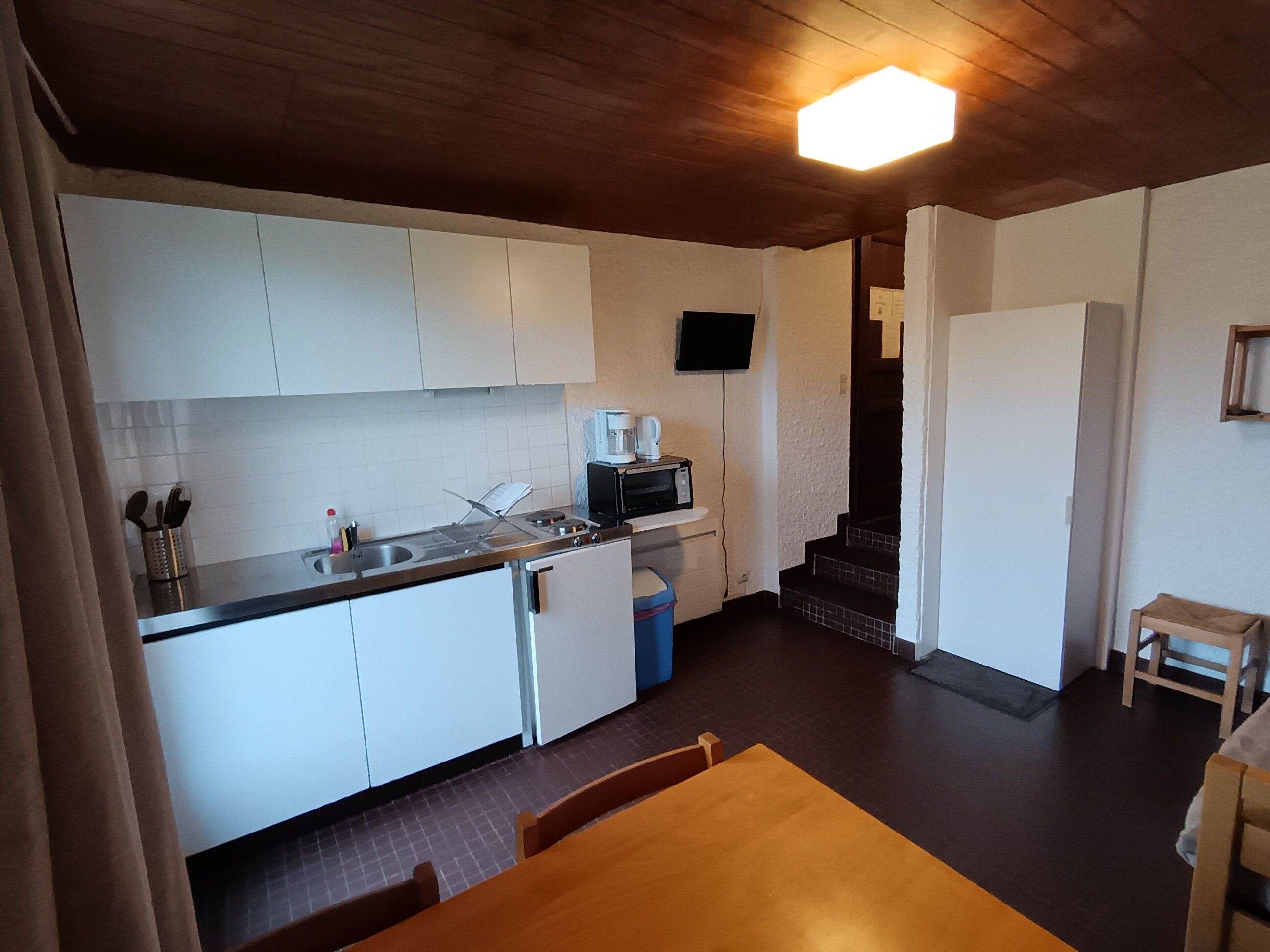 A compact kitchen with white cabinets, a microwave, and a coffee maker.