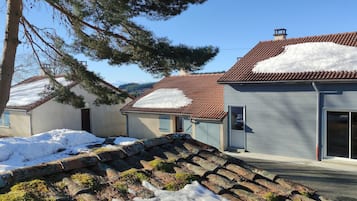 Un quartier résidentiel avec des maisons, dont certaines sont recouvertes de neige sur les toits, et un ciel dégagé.