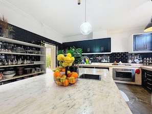 A modern kitchen with black cabinetry, a marble countertop, and a fruit bowl. - ZALUNA Marrakech Private Villa & Heated Pool (Sidi Bouzguia)