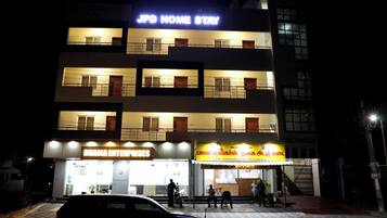 A multi-story building with signage for 'JPD HOME STAY' and 'BHAMA ENTERPRISES'.