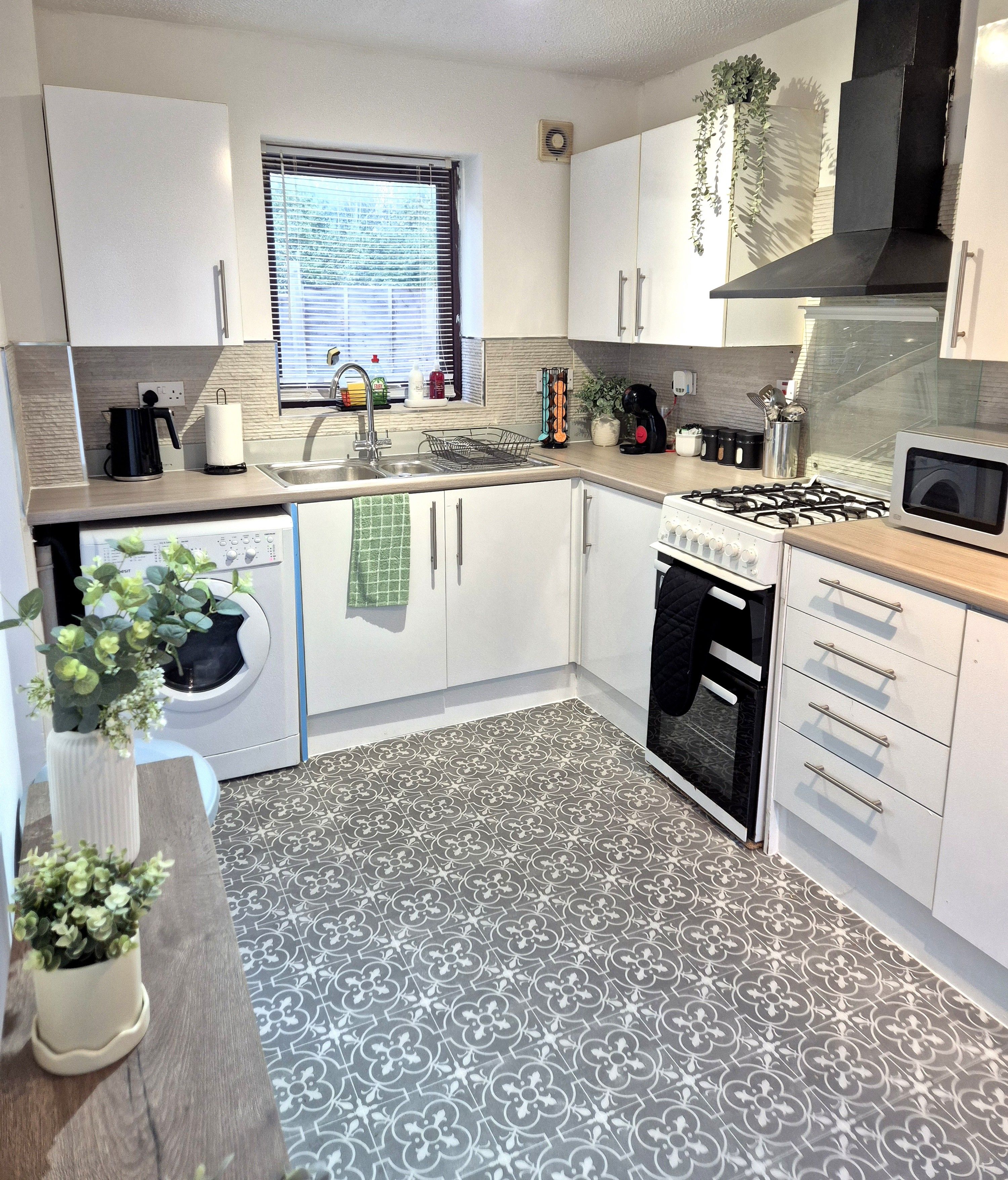 A modern kitchen with a built-in washing machine, a gas stove, and a microwave.