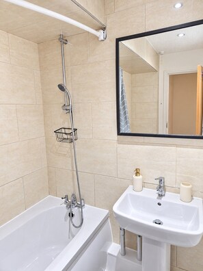 A bathroom with a bathtub, a sink, and a shower. - Cosy 2 Bedroom Home in Great Location (Shenley Lodge)