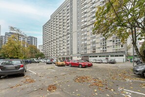 A parking lot with multiple cars and a large residential building in the background. - Lumina 2room Apart in Center I City View (Warszawa)