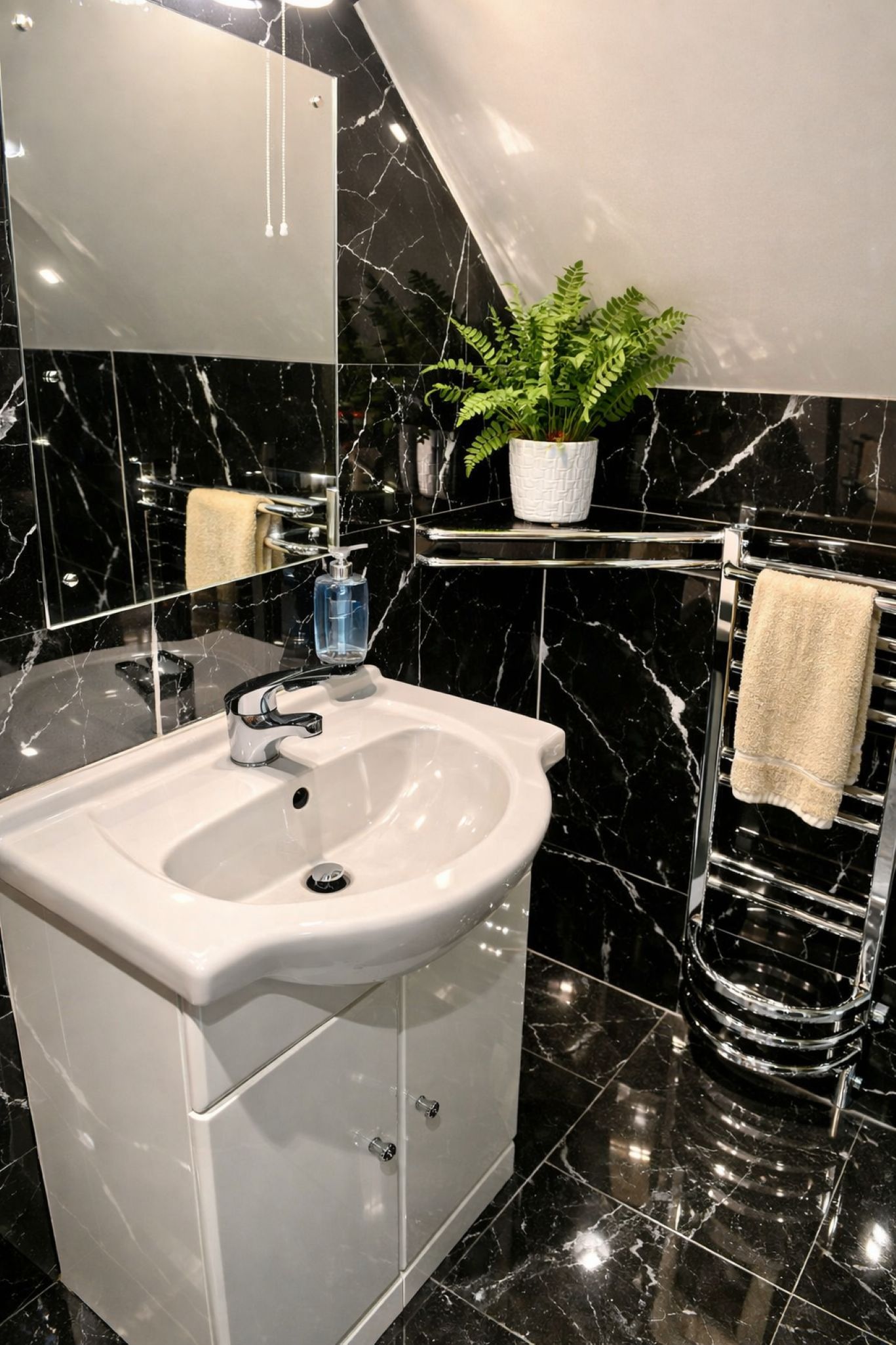 A bathroom with a white sink, a mirror, a plant on a shelf, and a towel rack.