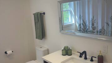 Un baño con inodoro, lavabo y espejo.
