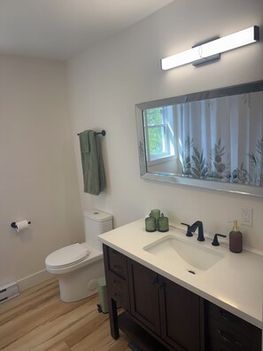 Un baño con inodoro, lavabo y espejo.