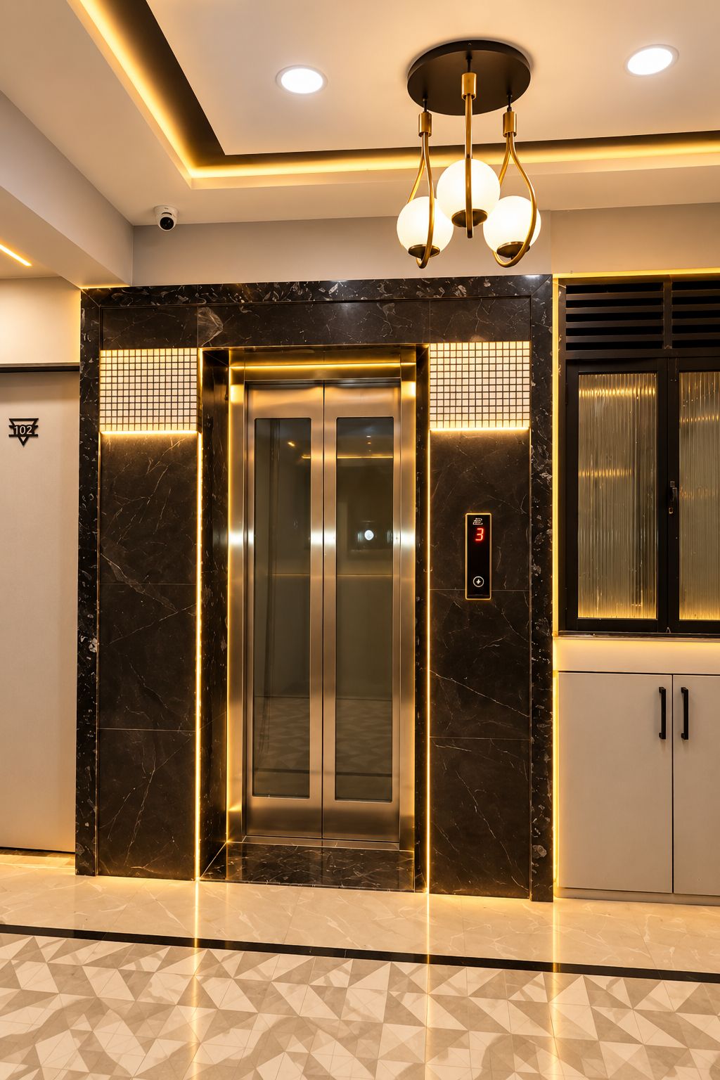 Un ascensor con pantalla digital, rodeado de paredes de mármol y un suelo con diseño geométrico.