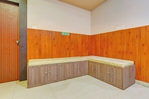 A corner room with a built-in bench, a door, and a fire exit sign. - Hotel O Kalinga Stadium Formerly Anusuya (Bhubaneshwar)