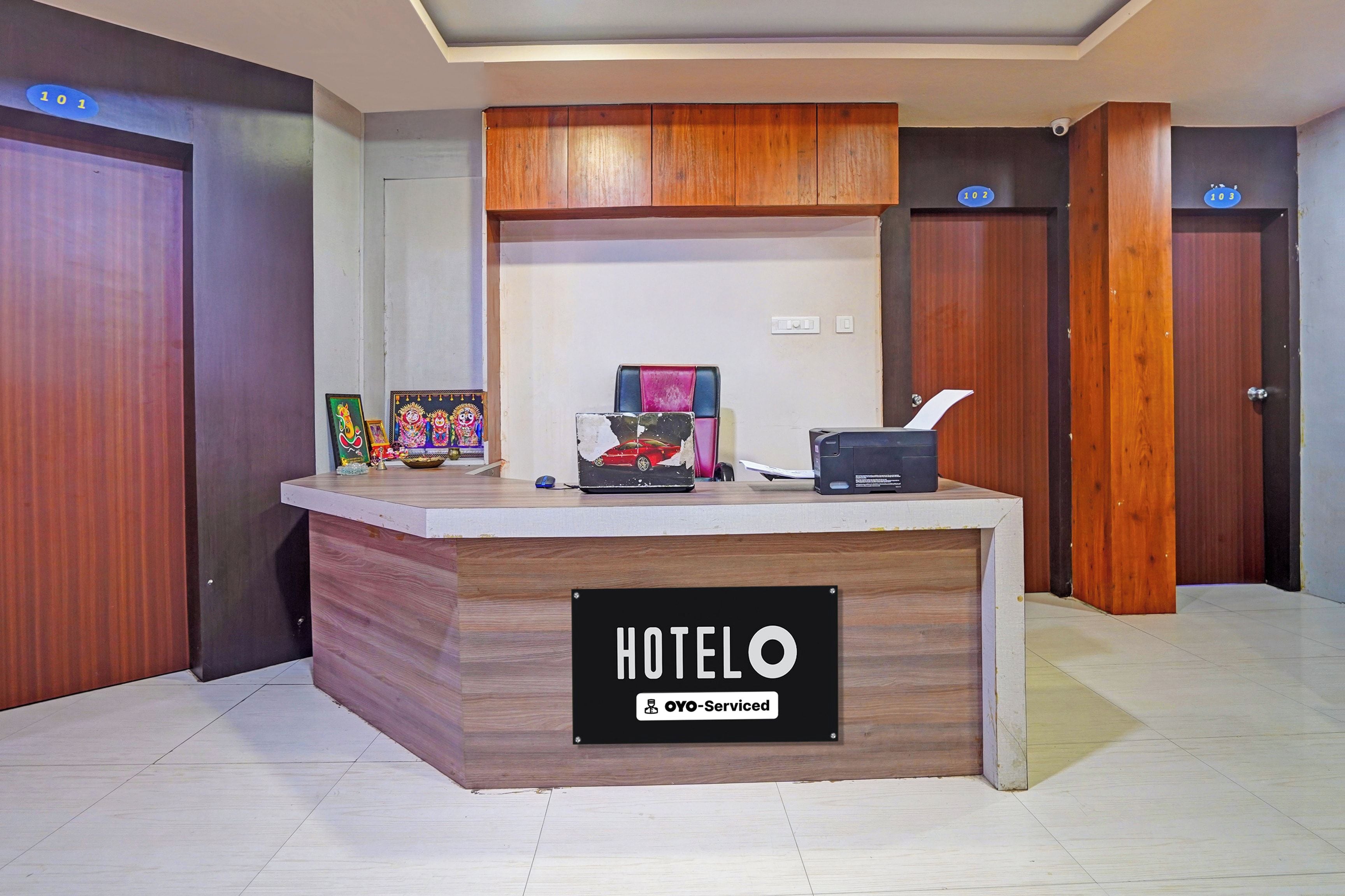 A hotel reception desk with a sign reading 'HOTELO & OYO-Serviced'.