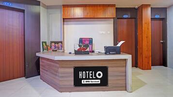 A hotel reception desk with a sign reading 'HOTELO & OYO-Serviced'.