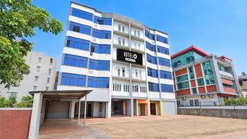 A multi-story hotel with a prominent 'HOTEL' sign, a covered entrance, and a parking area.