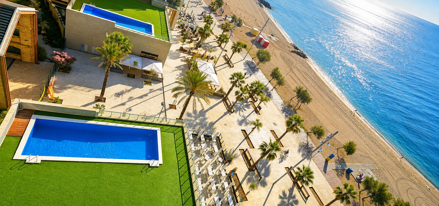 Ein Resort mit Swimmingpool, Strand und Palmen.