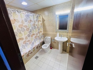 Een badkamer met toilet, wastafel en douchegordijn.