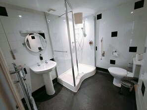 Un bagno moderno con doccia vetro, lavabo bianco e servizi igienici.
