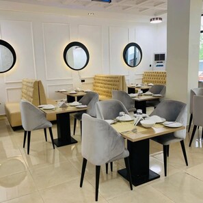 A dining area with round mirrors, cushioned seating, and a modern design. - EE 29 Hotel & Suites (Owerri)