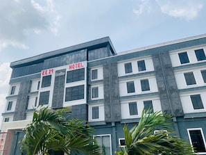 Un hotel de fachada moderna, con varios pisos y un cartel que indica que ofrece suites.