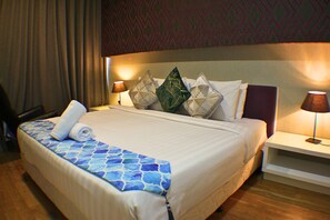 A hotel room with a neatly made bed, a side table with a lamp, and a patterned wall. - Skyline Service Suite KLCC at Platinum (Kuala Lumpur)