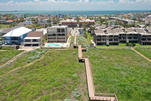 Una zona residencial con edificios modernos, una piscina y un amplio campo verde.