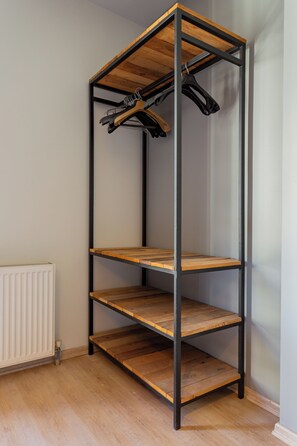 A multi-tiered metal shelving unit with wooden shelves, a radiator, and a plain wall. - Fabulous Large Duplex - 3 Bedroom 2 Bathroom - Terrace - Fast WiFi - Full Aircon (Şişli)