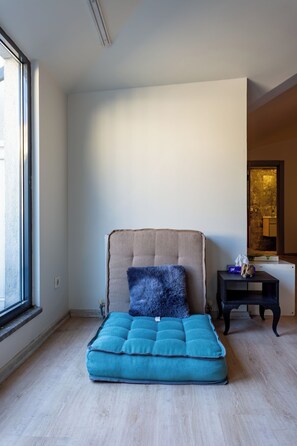 Ein Zimmer mit einem Bett, einem kleinen Tisch und einem Fenster.
