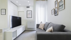 A modern living room with a flat-screen TV, a grey sofa, and a white cabinet. - Italianway Comfort - Soperga 15 (Milan)