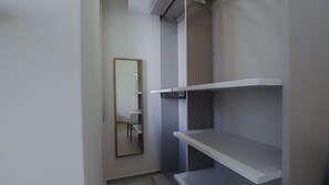 A room with a mirror, white shelving, and a door. - Italianway Comfort - Soperga 15 (Milan)