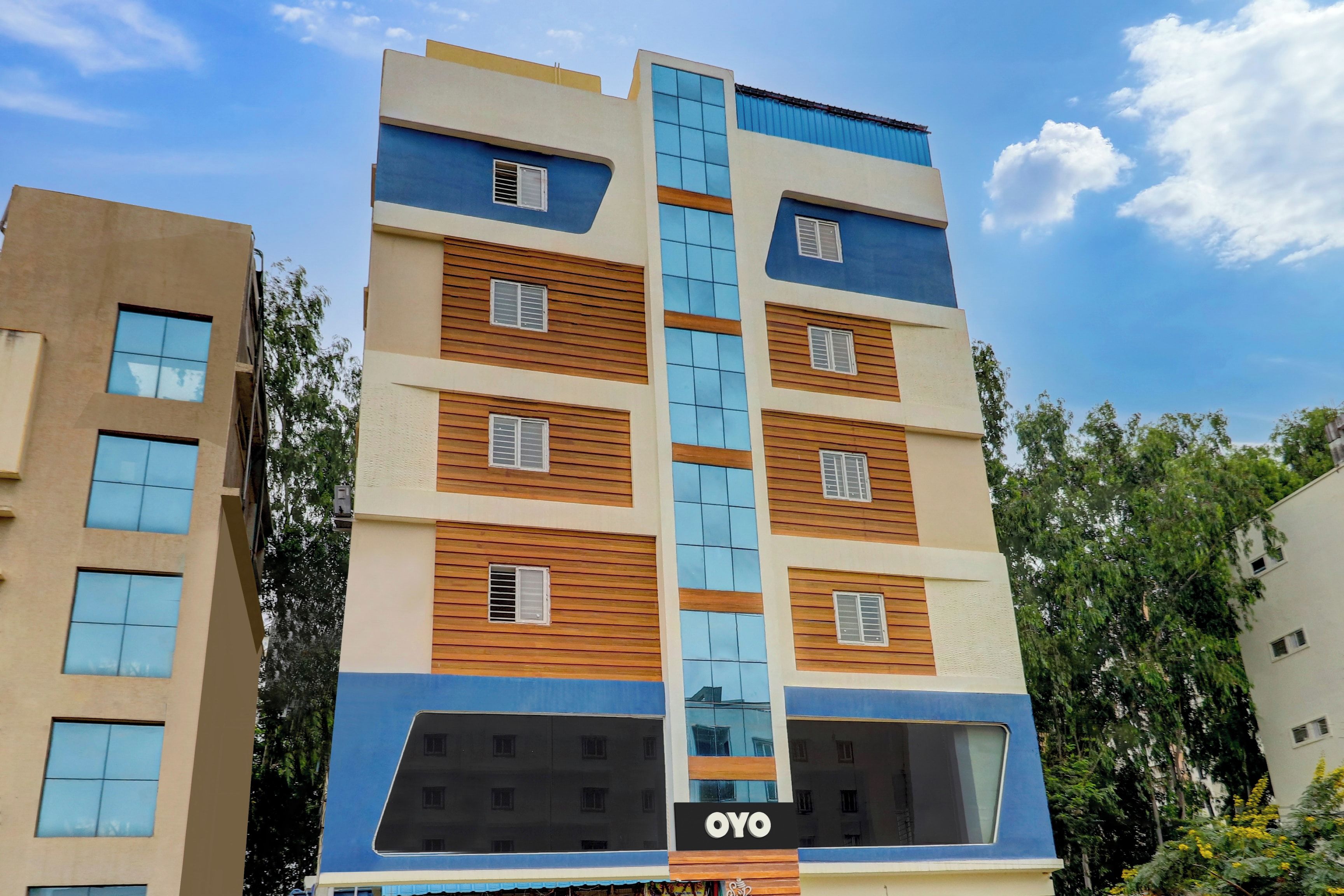 Un edificio de varios pisos con un llamativo letrero de 'OYO' en la base.