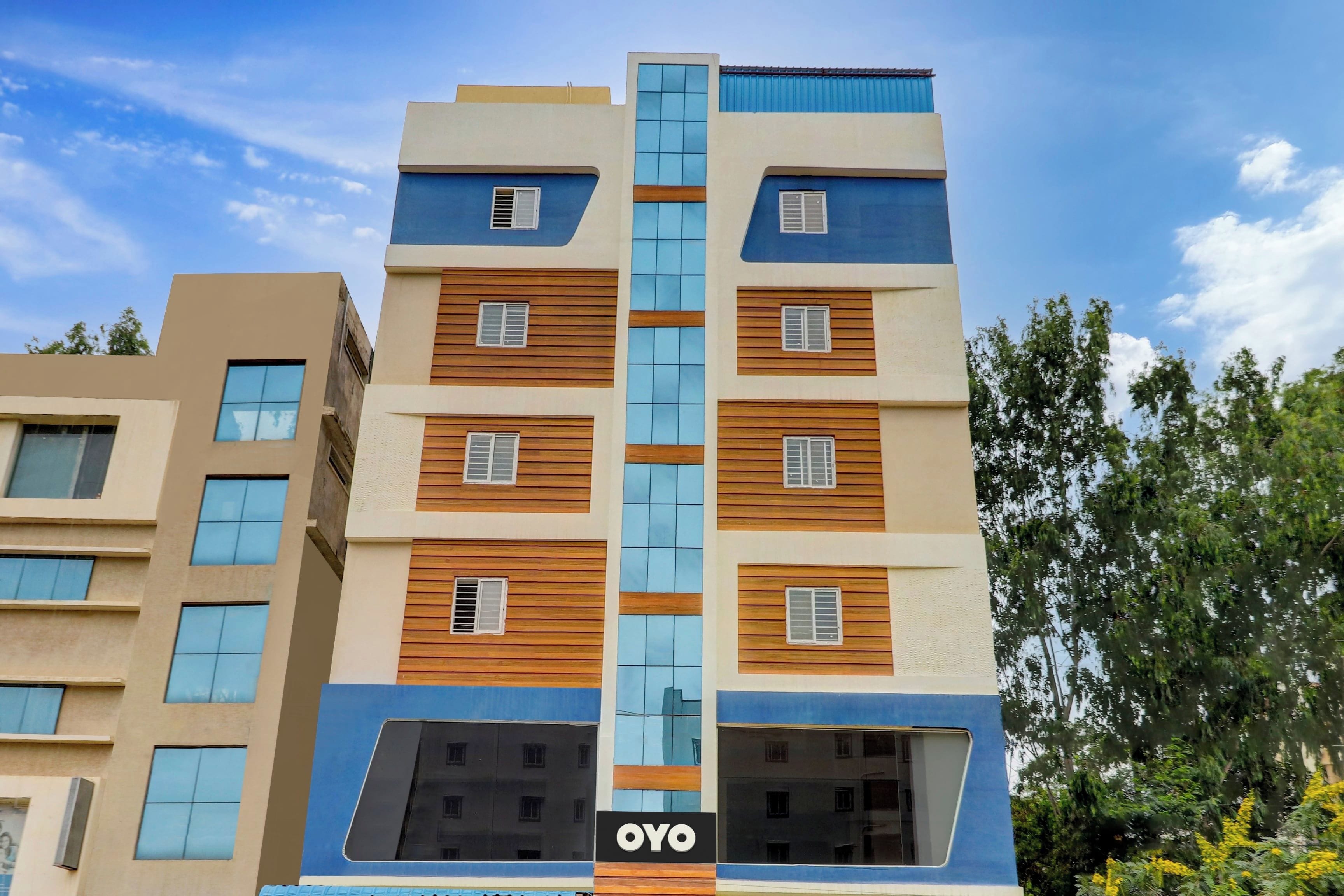 Un edificio de varios pisos con un diseño arquitectónico moderno, que combina fachadas de vidrio y paneles de madera.