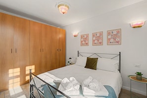 Un dormitorio con cama, armario e iluminación en la pared.