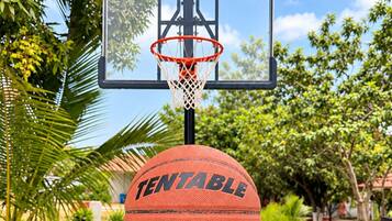 Un aro de baloncesto con red, un balón que dice 'TENTABLE PRO 7 OUTDOOR & INDOOR' y una mano sosteniendo la pelota.