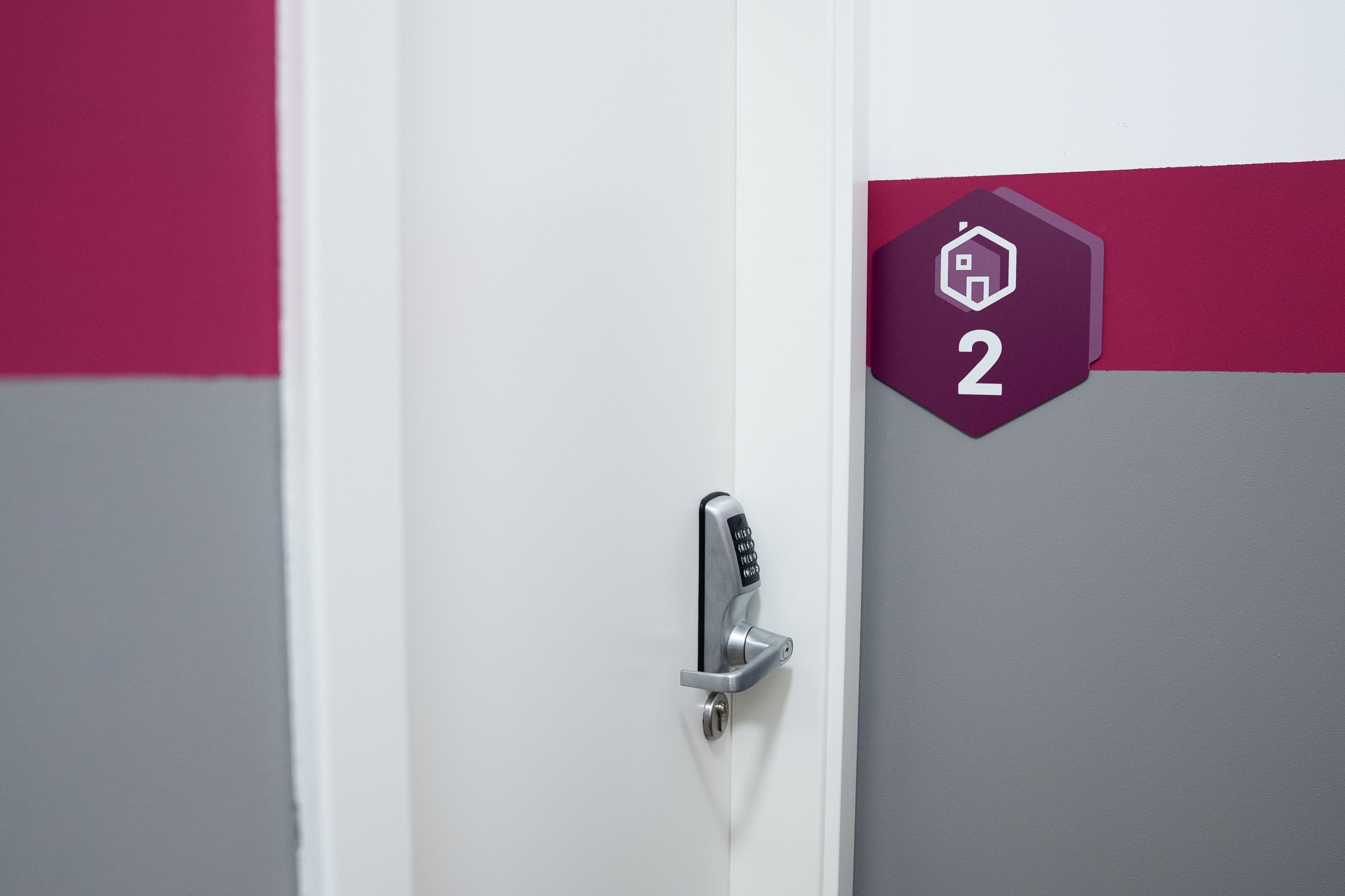 Une porte dotée d’un verrou à clavier numérique et d’une plaque indiquant le numéro de la porte.