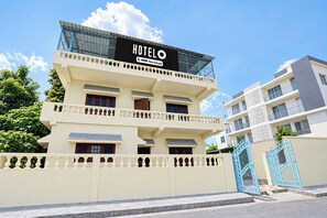 A hotel with a sign reading 'HOTEL OYO-Serviced' and a gated entrance. - otel O Uttaranchal University Road (Dehradun)