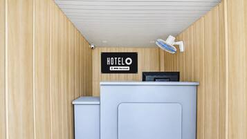 A hotel reception desk with a sign indicating it is OVO-serviced.