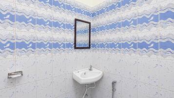 A bathroom with a sink, a mirror, and wave-patterned tiles.