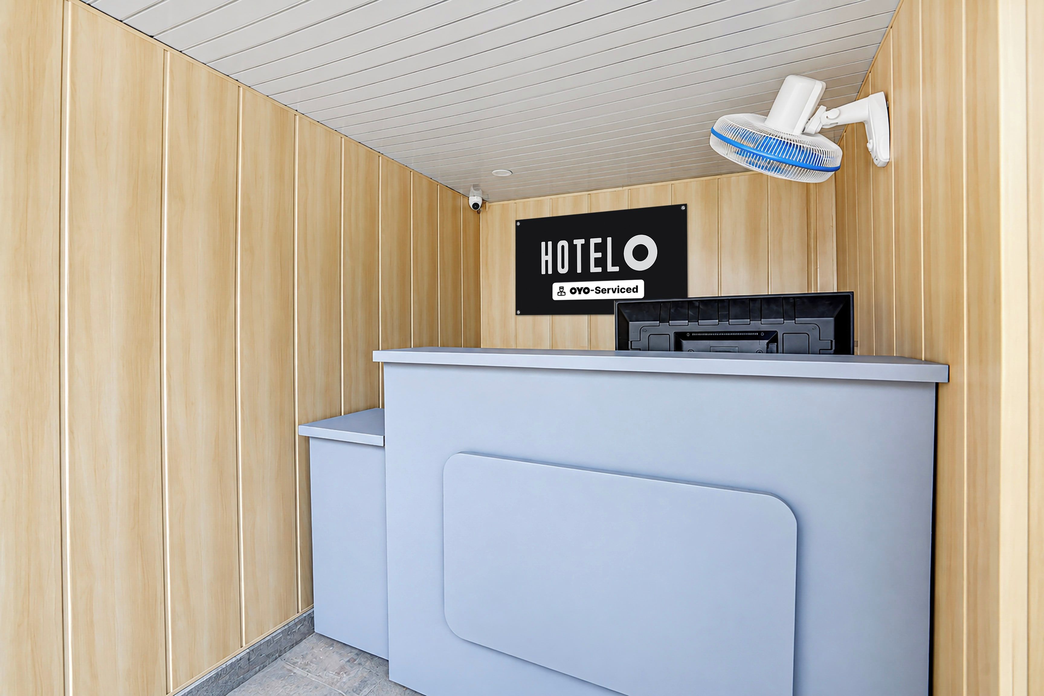 Un mostrador de recepción de hotel con un letrero que dice 'HOTEL OYO-Serviced'.